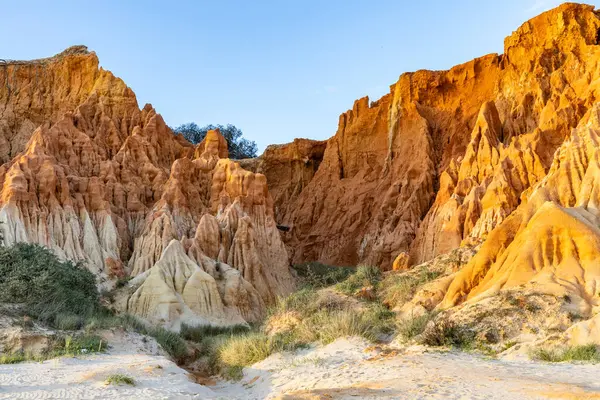 Bir çakıl taşı ve kumsalda inanılmaz kaya oluşumu. Kızıl topraklı kızıl kayalıklar ve kumlu sahilde inanılmaz oluşumlar. Praia da Falsia, sıcak güneş ışığıyla yıkanmış, Algarve, Portekiz