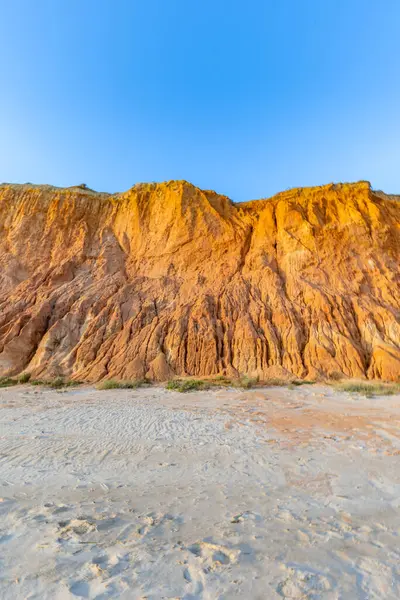 Bir çakıl taşı ve kumsalda inanılmaz kaya oluşumu. Kızıl topraklı kızıl kayalıklar ve kumlu sahilde inanılmaz oluşumlar. Praia da Falsia, sıcak güneş ışığıyla yıkanmış, Algarve, Portekiz