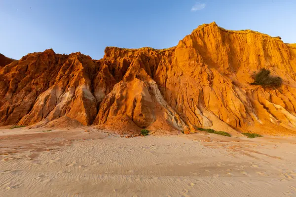 Bir çakıl taşı ve kumsalda inanılmaz kaya oluşumu. Kızıl topraklı kızıl kayalıklar ve kumlu sahilde inanılmaz oluşumlar. Praia da Falsia, sıcak güneş ışığıyla yıkanmış, Algarve, Portekiz