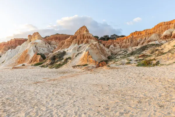 Bir çakıl taşı ve kumsalda inanılmaz kaya oluşumu. Kızıl topraklı kızıl kayalıklar ve kumlu sahilde inanılmaz oluşumlar. Praia da Falsia, sıcak güneş ışığıyla yıkanmış, Algarve, Portekiz