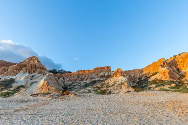 Bir çakıl taşı ve kumsalda inanılmaz kaya oluşumu. Kızıl topraklı kızıl kayalıklar ve kumlu sahilde inanılmaz oluşumlar. Praia da Falsia, sıcak güneş ışığıyla yıkanmış, Algarve, Portekiz