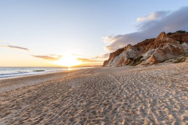 Praia da Falsia 'nın altın kumlu plajı. Karakteristik turuncu uçurumları. Akşam üzeri Portekiz' in Algarve kentindeki uçurumlarda çekilen manzara.