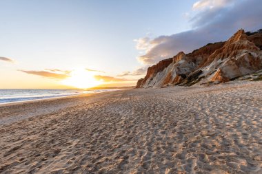 Praia da Falsia 'nın altın kumlu plajı. Karakteristik turuncu uçurumları. Akşam üzeri Portekiz' in Algarve kentindeki uçurumlarda çekilen manzara.