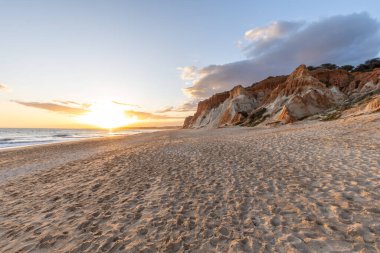 Praia da Falsia 'nın altın kumlu plajı. Karakteristik turuncu uçurumları. Akşam üzeri Portekiz' in Algarve kentindeki uçurumlarda çekilen manzara.