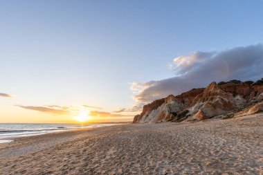 Praia da Falsia 'nın altın kumlu plajı. Karakteristik turuncu uçurumları. Akşam üzeri Portekiz' in Algarve kentindeki uçurumlarda çekilen manzara.