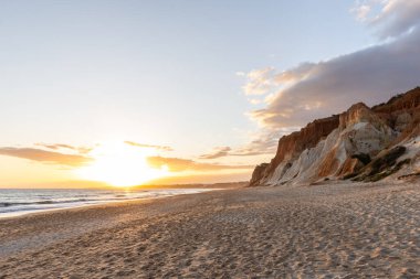 Praia da Falsia 'nın altın kumlu plajı. Karakteristik turuncu uçurumları. Akşam üzeri Portekiz' in Algarve kentindeki uçurumlarda çekilen manzara.