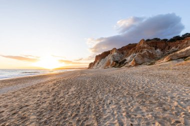 Praia da Falsia 'nın altın kumlu plajı. Karakteristik turuncu uçurumları. Akşam üzeri Portekiz' in Algarve kentindeki uçurumlarda çekilen manzara.
