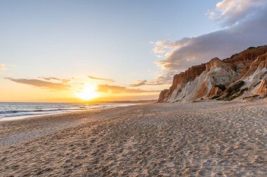 Praia da Falsia 'nın altın kumlu plajı. Karakteristik turuncu uçurumları. Akşam üzeri Portekiz' in Algarve kentindeki uçurumlarda çekilen manzara.