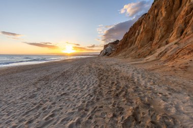 Praia da Falsia 'nın altın kumlu plajı. Karakteristik turuncu uçurumları. Akşam üzeri Portekiz' in Algarve kentindeki uçurumlarda çekilen manzara.