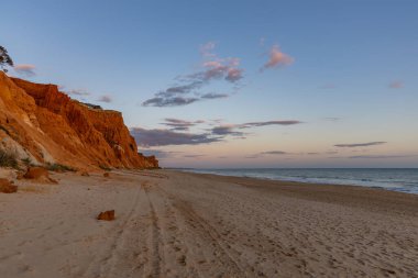 Praia da Falsia 'nın altın kumlu plajı. Karakteristik turuncu uçurumları. Akşam üzeri Portekiz' in Algarve kentindeki uçurumlarda çekilen manzara.