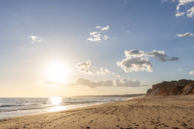 Praia da Falsia 'nın altın kumlu plajı. Karakteristik turuncu uçurumları. Akşam üzeri Portekiz' in Algarve kentindeki uçurumlarda çekilen manzara.