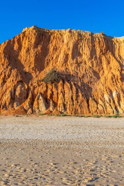 Praia da Falsia 'nın altın kumlu plajı. Karakteristik turuncu uçurumları. Akşam üzeri Portekiz' in Algarve kentindeki uçurumlarda çekilen manzara.