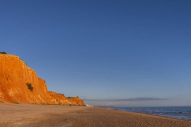 Praia da Falsia 'nın altın kumlu plajı. Karakteristik turuncu uçurumları. Akşam üzeri Portekiz' in Algarve kentindeki uçurumlarda çekilen manzara.