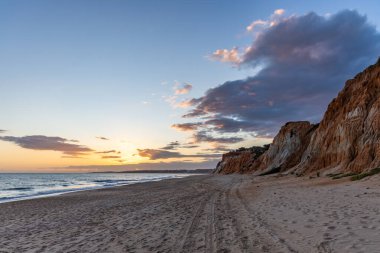Praia da Falsia 'nın altın kumlu plajı. Karakteristik turuncu uçurumları. Akşam üzeri Portekiz' in Algarve kentindeki uçurumlarda çekilen manzara.