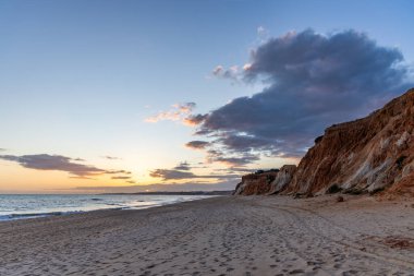 Praia da Falsia 'nın altın kumlu plajı. Karakteristik turuncu uçurumları. Akşam üzeri Portekiz' in Algarve kentindeki uçurumlarda çekilen manzara.