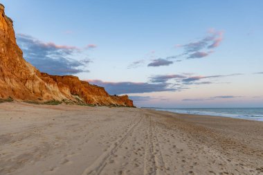 Praia da Falsia 'nın altın kumlu plajı. Karakteristik turuncu uçurumları. Akşam üzeri Portekiz' in Algarve kentindeki uçurumlarda çekilen manzara.