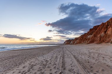 Praia da Falsia 'nın altın kumlu plajı. Karakteristik turuncu uçurumları. Akşam üzeri Portekiz' in Algarve kentindeki uçurumlarda çekilen manzara.
