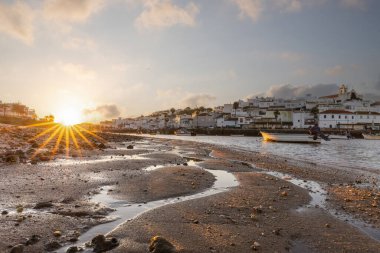 Kumsala bakan bir gün doğumu ve alçak gelgitte liman. Ferragudo, Portimo, Algarve, Portekiz 'deki tarihi bir kasabanın panoramik sabah manzarası