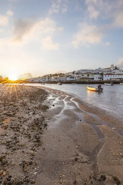 Kumsala bakan bir gün doğumu ve alçak gelgitte liman. Ferragudo, Portimo, Algarve, Portekiz 'deki tarihi bir kasabanın panoramik sabah manzarası