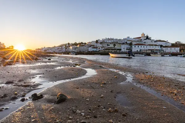 Kumsala bakan bir gün doğumu ve alçak gelgitte liman. Ferragudo, Portimo, Algarve, Portekiz 'deki tarihi bir kasabanın panoramik sabah manzarası