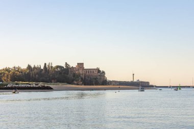 Atlantik 'te gün doğumu, sahilin ortasında bir kale. Limanı koruyan tarihi bir bina. Castelo de Ferragudo, kumlu Praia da Angrinha sahilinde, Portimo, Algarve, Portekiz