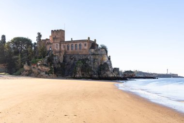 Atlantik 'te gün doğumu, sahilin ortasında bir kale. Limanı koruyan tarihi bir bina. Castelo de Ferragudo, kumlu Praia da Angrinha sahilinde, Portimo, Algarve, Portekiz