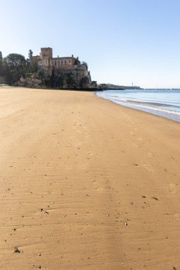 Atlantik 'te gün doğumu, sahilin ortasında bir kale. Limanı koruyan tarihi bir bina. Castelo de Ferragudo, kumlu Praia da Angrinha sahilinde, Portimo, Algarve, Portekiz