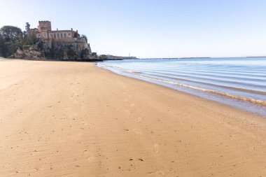 Ferragudo Kalesi bir liman körfezindeki kumlu bir sahilde yer almaktadır. Mavi gökyüzü ve yumuşak dalgalarla kumlu sahilde sabah ışığı. Praia da Angrinha, Ferragudo, Portimo, Algarve, Portekiz
