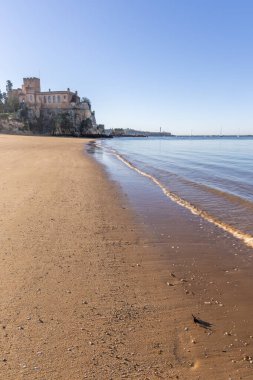 Ferragudo Kalesi bir liman körfezindeki kumlu bir sahilde yer almaktadır. Mavi gökyüzü ve yumuşak dalgalarla kumlu sahilde sabah ışığı. Praia da Angrinha, Ferragudo, Portimo, Algarve, Portekiz