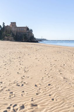 Ferragudo Kalesi bir liman körfezindeki kumlu bir sahilde yer almaktadır. Mavi gökyüzü ve yumuşak dalgalarla kumlu sahilde sabah ışığı. Praia da Angrinha, Ferragudo, Portimo, Algarve, Portekiz