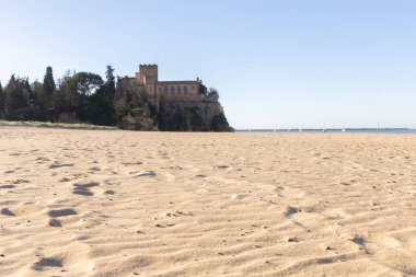 Ferragudo Kalesi bir liman körfezindeki kumlu bir sahilde yer almaktadır. Mavi gökyüzü ve yumuşak dalgalarla kumlu sahilde sabah ışığı. Praia da Angrinha, Ferragudo, Portimo, Algarve, Portekiz