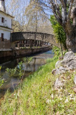 Çitlerle çevrili bir bahar, bazen yüzme havuzuna dönüşen tarihi bir yer. Praia Fluvial de Alte 'nin eski duvarları, Algarve, Portekiz