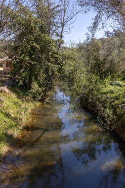 Çitlerle çevrili bir bahar, bazen yüzme havuzuna dönüşen tarihi bir yer. Praia Fluvial de Alte 'nin eski duvarları, Algarve, Portekiz