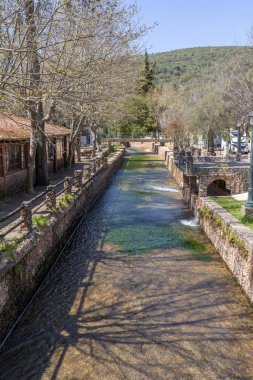 Çitlerle çevrili bir bahar, bazen yüzme havuzuna dönüşen tarihi bir yer. Praia Fluvial de Alte 'nin eski duvarları, Algarve, Portekiz