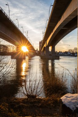 Eski tarihi bir şehir kapısından bir yol ya da otoyol geçiyor. Solucanlar, Almanya yakınlarındaki Ren nehrinde akşam üstü gün batımı