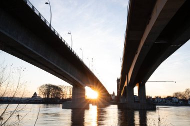 Eski tarihi bir şehir kapısından bir yol ya da otoyol geçiyor. Solucanlar, Almanya yakınlarındaki Ren nehrinde akşam üstü gün batımı