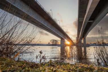 Eski tarihi bir şehir kapısından bir yol ya da otoyol geçiyor. Solucanlar, Almanya yakınlarındaki Ren nehrinde akşam üstü gün batımı