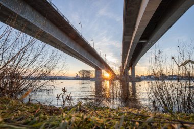 Eski tarihi bir şehir kapısından bir yol ya da otoyol geçiyor. Solucanlar, Almanya yakınlarındaki Ren nehrinde akşam üstü gün batımı