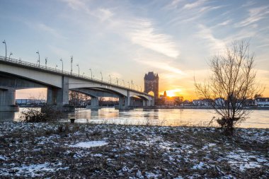 Eski tarihi bir şehir kapısından bir yol ya da otoyol geçiyor. Solucanlar, Almanya yakınlarındaki Ren nehrinde akşam üstü gün batımı