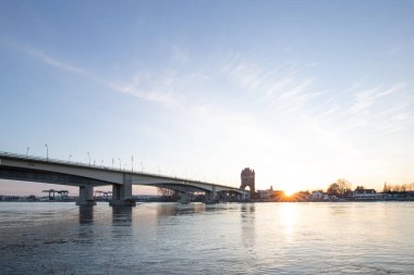 Eski tarihi bir şehir kapısından bir yol ya da otoyol geçiyor. Solucanlar, Almanya yakınlarındaki Ren nehrinde akşam üstü gün batımı