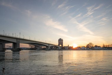 Eski tarihi bir şehir kapısından bir yol ya da otoyol geçiyor. Solucanlar, Almanya yakınlarındaki Ren nehrinde akşam üstü gün batımı