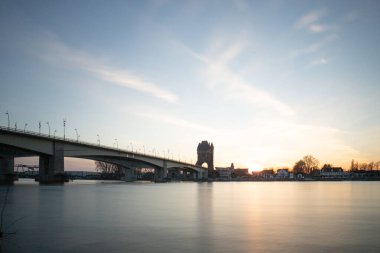 Eski tarihi bir şehir kapısından bir yol ya da otoyol geçiyor. Solucanlar, Almanya yakınlarındaki Ren nehrinde akşam üstü gün batımı