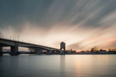 Eski tarihi bir şehir kapısından bir yol ya da otoyol geçiyor. Solucanlar, Almanya yakınlarındaki Ren nehrinde akşam üstü gün batımı