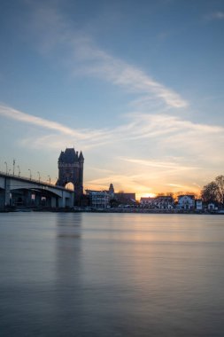 Eski tarihi bir şehir kapısından bir yol ya da otoyol geçiyor. Solucanlar, Almanya yakınlarındaki Ren nehrinde akşam üstü gün batımı