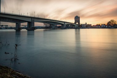 Eski tarihi bir şehir kapısından bir yol ya da otoyol geçiyor. Solucanlar, Almanya yakınlarındaki Ren nehrinde akşam üstü gün batımı