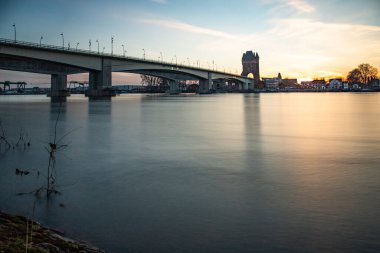 Eski tarihi bir şehir kapısından bir yol ya da otoyol geçiyor. Solucanlar, Almanya yakınlarındaki Ren nehrinde akşam üstü gün batımı