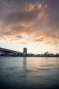 Eski tarihi bir şehir kapısından bir yol ya da otoyol geçiyor. Solucanlar, Almanya yakınlarındaki Ren nehrinde akşam üstü gün batımı