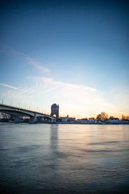 Eski tarihi bir şehir kapısından bir yol ya da otoyol geçiyor. Solucanlar, Almanya yakınlarındaki Ren nehrinde akşam üstü gün batımı
