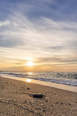 Gün batımında kumlu ve çakıl taşı plajı olan güzel bir sahil şeridi. Platanes Beach, Rethymno, Girit, Yunanistan 'ın turizm ve otel bölgesinde güzel gökyüzü renklendirmesi