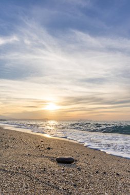 Gün batımında kumlu ve çakıl taşı plajı olan güzel bir sahil şeridi. Platanes Beach, Rethymno, Girit, Yunanistan 'ın turizm ve otel bölgesinde güzel gökyüzü renklendirmesi